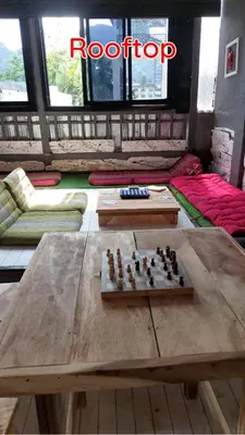 a room with a wooden table with a chessboard on it at Dormsin Chill in Phi Phi Don