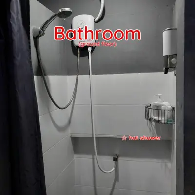a shower in a bathroom with a hose on the wall at Dormsin Chill in Phi Phi Don
