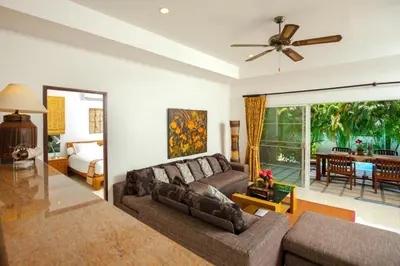 a living room with a couch and a ceiling fan at Romanee Villa by G Estate in Rawai Beach