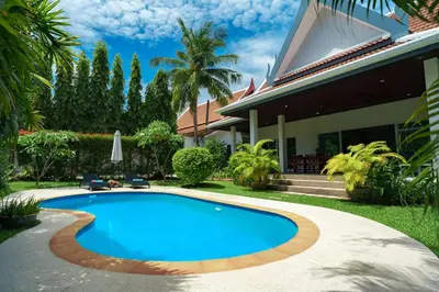 a swimming pool in front of a house at Montaplan Villa by G Estate in Rawai Beach