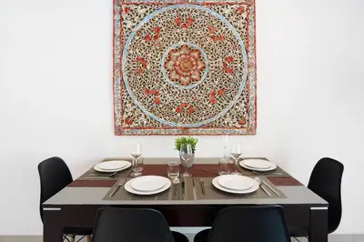a dining room table with chairs and a rug on the wall at Montaplan Villa by G Estate in Rawai Beach