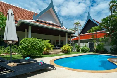 a villa with a swimming pool in front of a house at Montaplan Villa by G Estate in Rawai Beach
