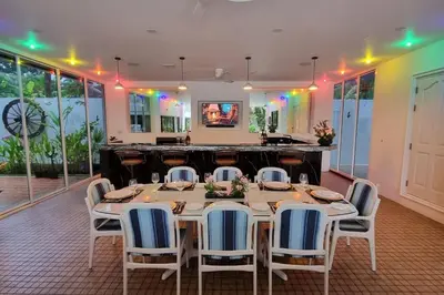 a dining room with a long table and chairs at Baan Paa Phuket - 6 Bedrooms Villa in Rawai Beach