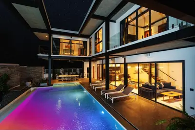an indoor swimming pool in a house at night at Totally New 4BR Private Villa Sunset Garden 2, 12m Oxygen Pool in Rawai Beach