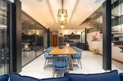 a dining room with a wooden table and blue chairs at Totally New 4BR Private Villa Sunset Garden 2, 12m Oxygen Pool in Rawai Beach