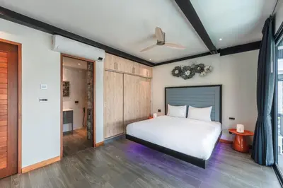 a bedroom with a white bed and wooden floors at Totally New 4BR Private Villa Sunset Garden 2, 12m Oxygen Pool in Rawai Beach