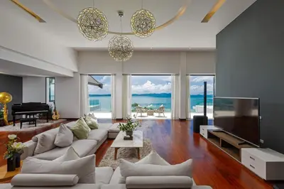 a living room with a white couch and a television at Villa Arun in Phuket Town