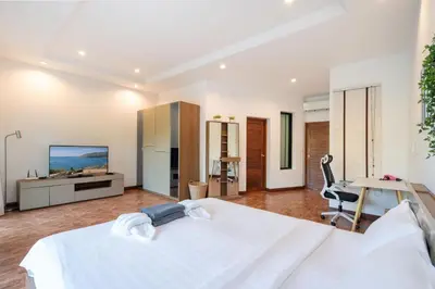 a bedroom with a large white bed and a desk at Kamala Beach 3-bedroom villa near Fantasea with high-speed Wi-Fi and private pool in Kamala Beach