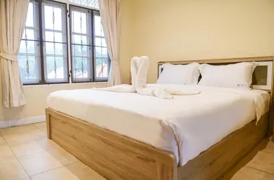a bedroom with a large bed with white sheets and pillows at Shimmer Three-Bedroom Villa with large garden and two swimming pools in Rawai Beach