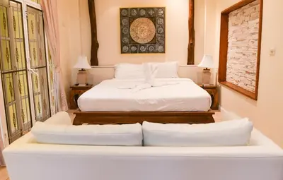 a bedroom with a bed and two couches at Shimmer Three-Bedroom Villa with large garden and two swimming pools in Rawai Beach
