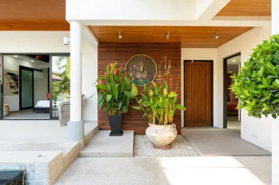 a house with plants in front of a door at The Thara Villa Surin Beach in Surin Beach