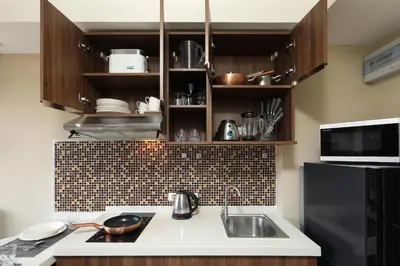 a kitchen with a sink and a black refrigerator at Naiharn Sea Condo by Capital Pro in Phuket Town