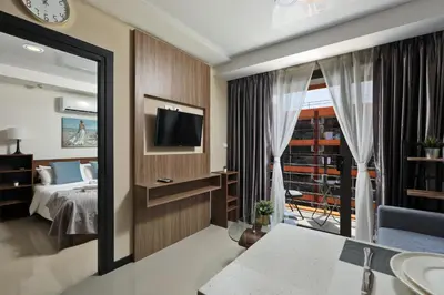 a hotel room with a bed and a television at 1bdr Apartment Naiharn Beach Condo by CapitalPro in Phuket Town