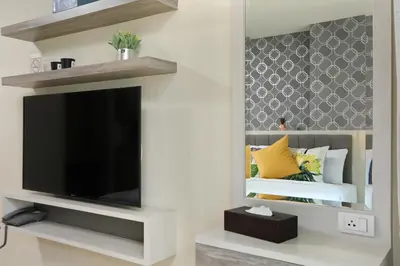 a living room with a flat screen tv and a bed at 1bdr Apartment on the Kata Beach SPL-101 by Capital Pro in Phuket Town