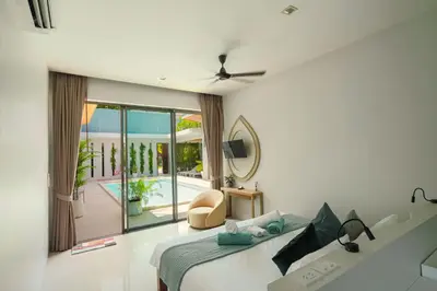 a bedroom with a bed and a view of a pool at Villa Mimosa 2, Splendid 3 Bedroom Master Ensuite in Phuket Town