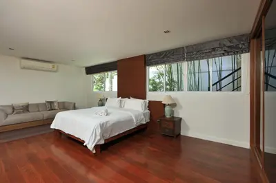 a bedroom with a large bed and a couch at Dolphin Villa in Patong Beach