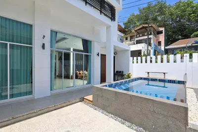 a villa with a swimming pool and a house at Dolphin Villa in Patong Beach