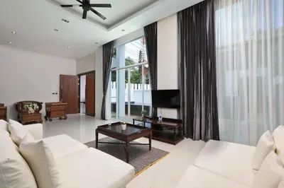 a living room with white furniture and a large window at Dolphin Villa in Patong Beach