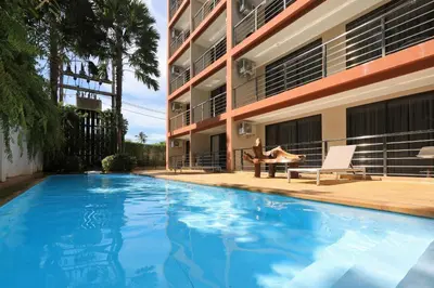 a woman sitting in a chair next to a swimming pool at New apartment Rawai Beach 218 by Capital Pro in Phuket Town