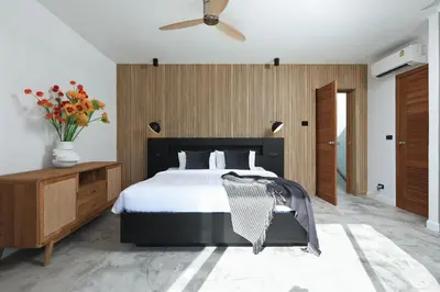 a bedroom with a bed and a ceiling fan at New 4 bedroom pool villa in Rawai by Capital Pro in Phuket Town