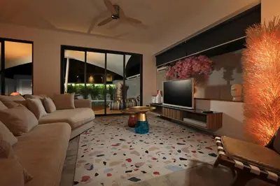 a living room with a couch and a tv at New 4 bedroom pool villa in Rawai by Capital Pro in Phuket Town