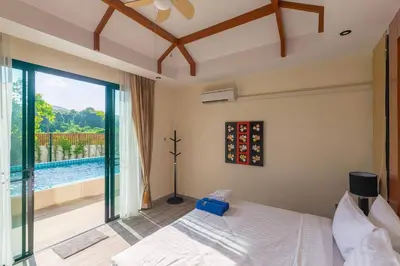 a bedroom with a bed and a view of a pool at 3bdr VIP Villa Rawai with private pool in Phuket Town
