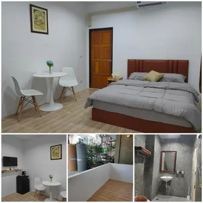 a bedroom with a bed and a table and a chair at Phudis Guest House in Ban Khlong Haeng