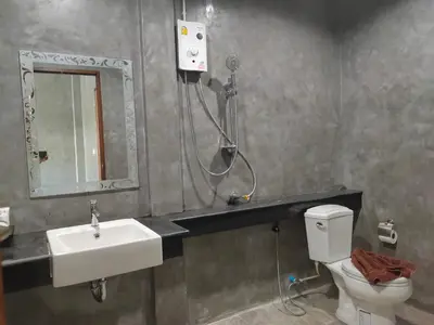 a bathroom with a toilet and a sink and a shower at Phudis Guest House in Ban Khlong Haeng