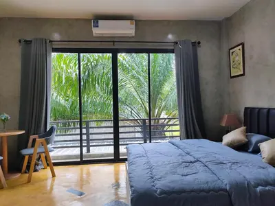 a bedroom with a bed and a large window at Phudis Guest House in Ban Khlong Haeng
