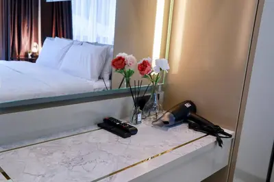 a bedroom with a mirror and a phone and flowers at A401-Silk Condo Aonang, Sea view - 5 mins to beach in Krabi town