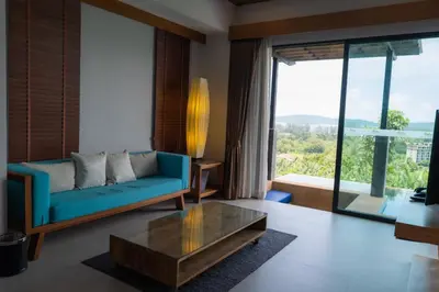 a living room with a blue couch and a table at Aonang Suite Pool Villa in Ao Nang Beach