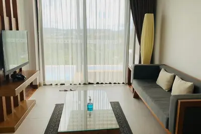 a living room with a couch and a tv at Aonang Suite Pool Villa in Ao Nang Beach