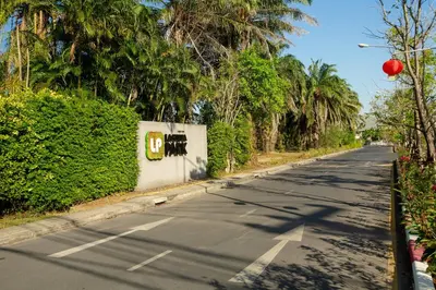 an empty street with palm trees on the side of the road at 3bdr Townhouse Laguna Park by CapitalPro 131 in Phuket Town