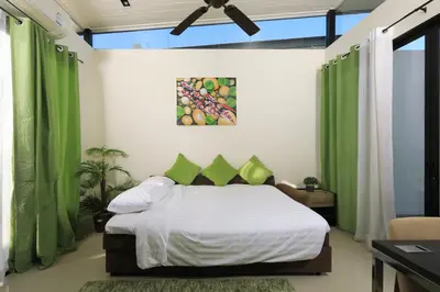 a bedroom with a bed with green curtains at 3bdr Townhouse Laguna Park Bangtao Beach by CapitalPro in Phuket Town