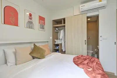 a bedroom with a bed with white sheets and pillows at Bangtao beach Cozy apartments by Capitalpro in Phuket Town