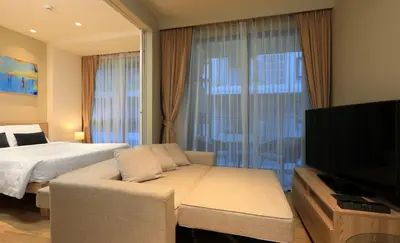 a bedroom with a bed and a couch and a tv at 1bdr Cozy apartment in Diamond Resort Bangtao Beach by Capital Pro in Phuket Town