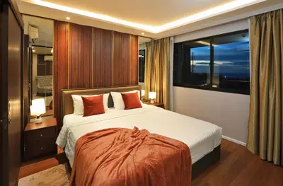 a bedroom with a bed and a large window at 3 bdr SeaView Apartment walking to Surin Beach by CapitalPro in Phuket Town