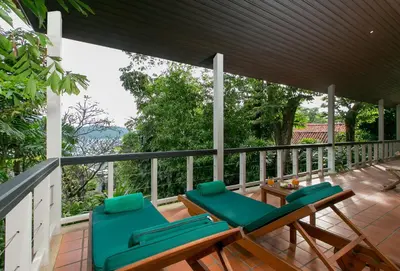 a deck with two chairs and a table at Katamanda villa Sooksan Near Kata Noi Beach in Kata Beach