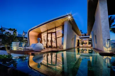 a villa with a swimming pool at night at Iniala Beach House in Natai Beach