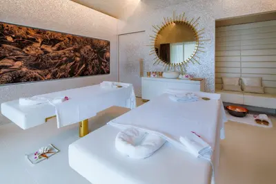 a white room with two beds and a mirror at Iniala Beach House in Natai Beach