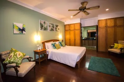 a bedroom with a bed and a chair in a room at Villa Oriole in Layan Beach