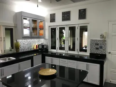 a kitchen with black counter tops and white cabinets at Villa Oriole in Layan Beach