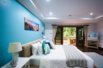 a bedroom with a bed with a blue wall at Villa Oriole in Layan Beach