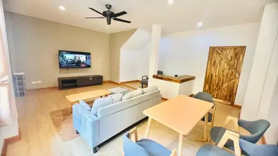 a living room with a couch and a tv at My Friend's House Villa in Karon Beach