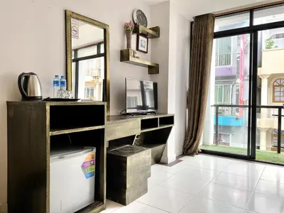 a room with a mirror and a desk and a window at Beachwalk Patong in Patong Beach