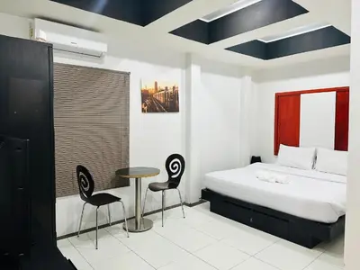 a bedroom with a bed and a table and chairs at Beachwalk Patong in Patong Beach