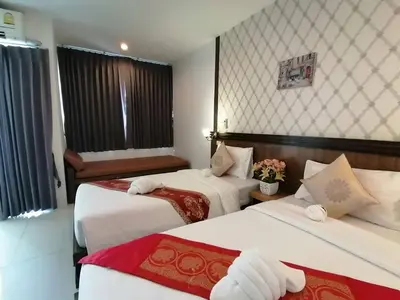a hotel room with two beds with flowers on them at NJ PATONG HOTEL in Patong Beach