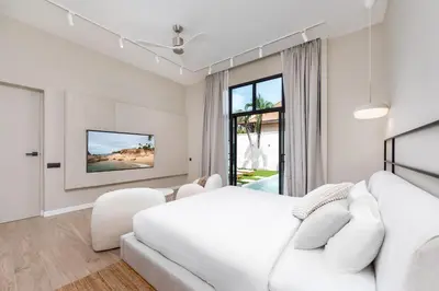 a white bedroom with a white bed and a white couch at Onyx Villas by TropicLook in Nai Harn Beach