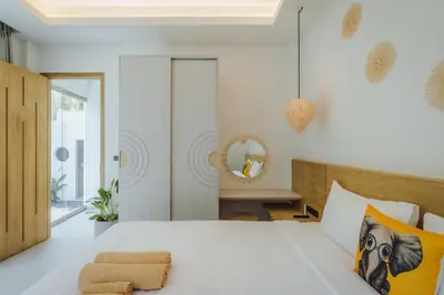 a bedroom with a large white bed and a mirror at Modern Rustic 4 Bedrooms Villa, Walk to Rawai & Yanui Beach in Nai Harn Beach