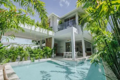 an exterior view of a house with a swimming pool and trees at Modern Rustic 4 Bedrooms Villa, Walk to Rawai & Yanui Beach in Nai Harn Beach
